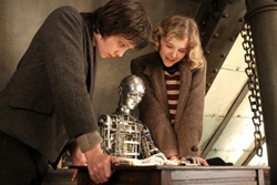 Hugo and Isabelle watch as Melies' automaton draws a magical image.