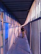Thomas walking up the barred walkway to the Bethlehem checkpoint.